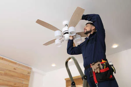 167713327-electrician-repairing-ceiling-fan-with-lamps-indoors-space-for-text
